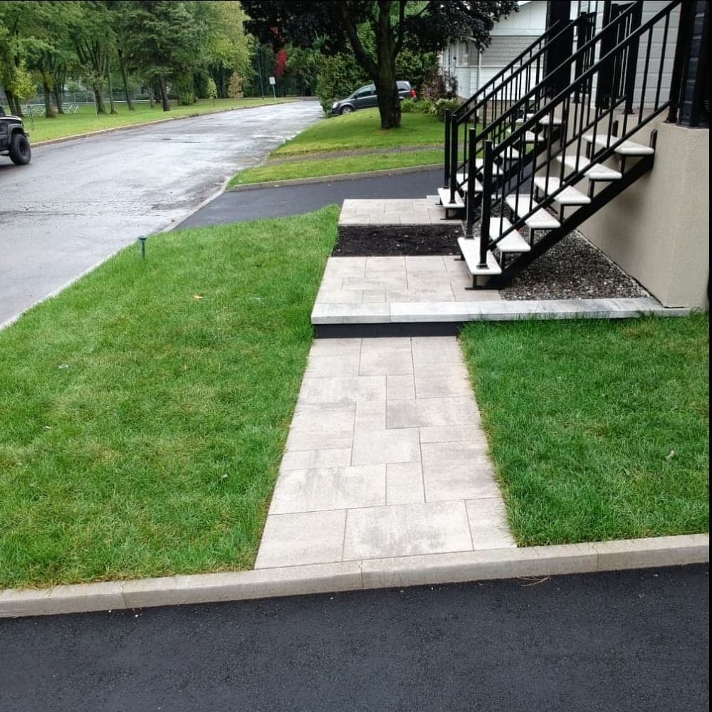 Après les travaux — entrée de duplex avec escalier métallique, allée en dalles et pelouse