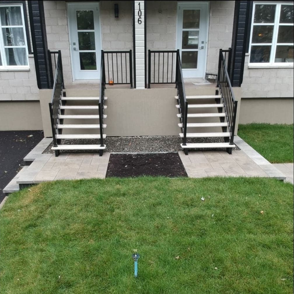 Après les travaux — façade de duplex avec escaliers métalliques, allées en dalles et pelouse