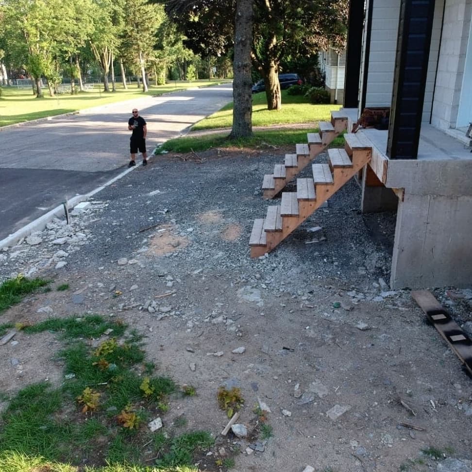 Avant les travaux — entrée de duplex avec escalier temporaire et terrain non aménagé