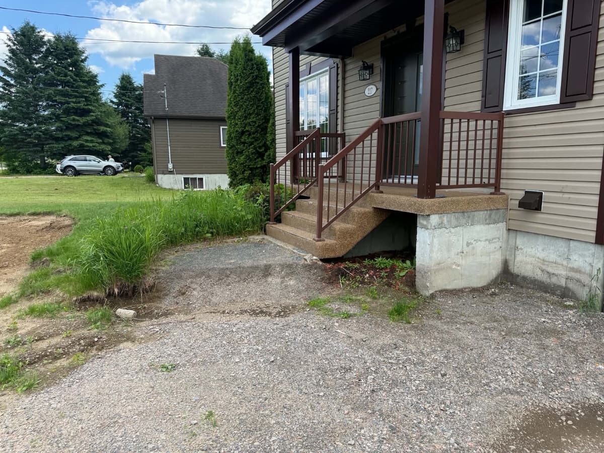Avant les travaux — entrée de maison sur gravier avec fondation exposée à Shannon