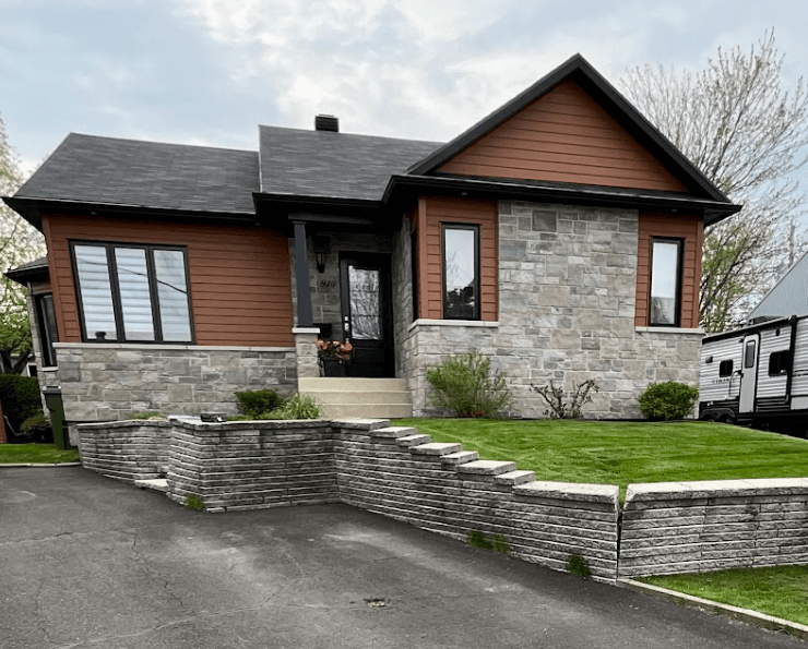 Avant les travaux — façade avec muret de pierre et entrée asphaltée à Lévis