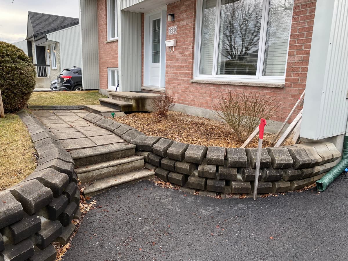 Avant les travaux — muret de blocs affaissé et allée en béton devant une maison à Neufchâtel