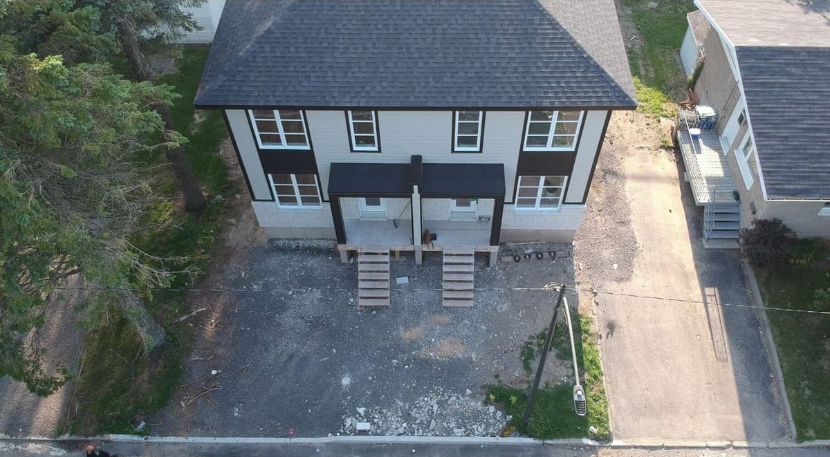 Avant les travaux — vue aérienne d’un duplex avec cour en gravier et escaliers temporaires