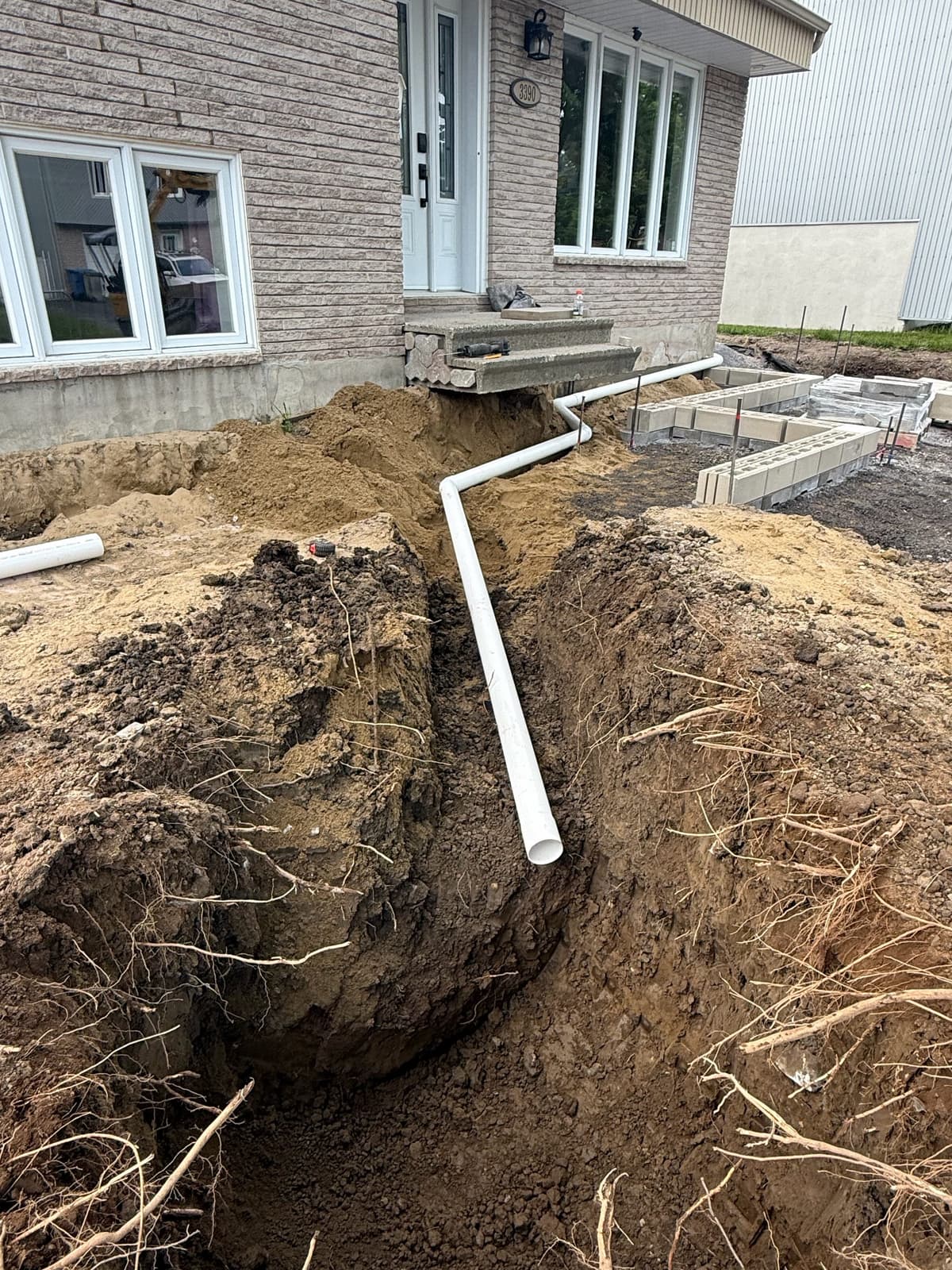 Before work began — trench excavation and drainage work in front of a residential property