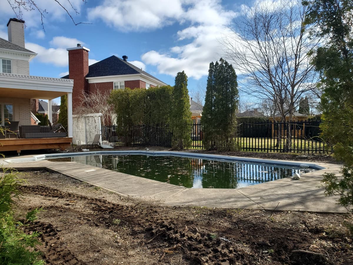 Avant les travaux — piscine creusée avec contour en béton et terrain non aménagé autour de la zone de baignade