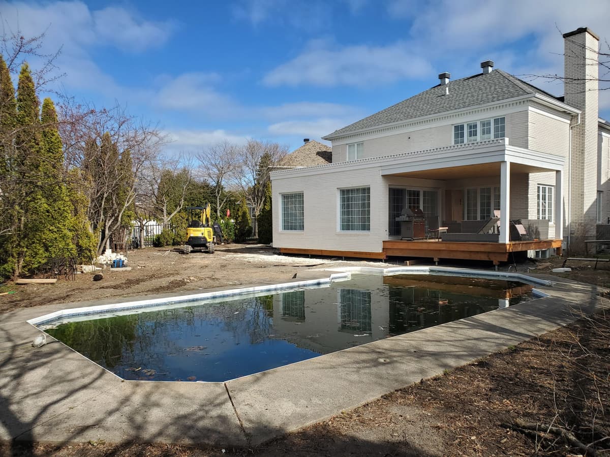 Avant les travaux — cour arrière avec piscine creusée et contour en béton, avant l’aménagement du pavé et des espaces extérieurs