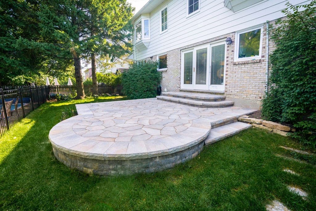 Après les travaux — terrasse ronde en pierre naturelle avec muret et marches à Sainte-Foy